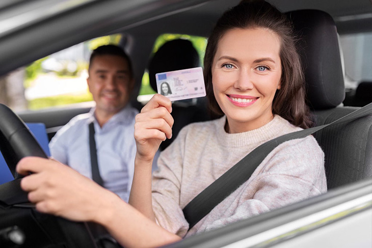 kobieta w samochodzie trzyma nowe prawo jazdy